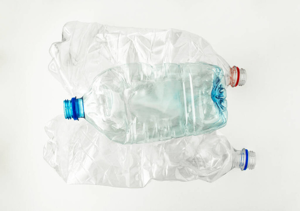 白い背景にキャップのない3つの透明なプラスチックボトル。プラスチックのリサイクル。ガベージコレクションと分別。加工用原料. - 写真・画像