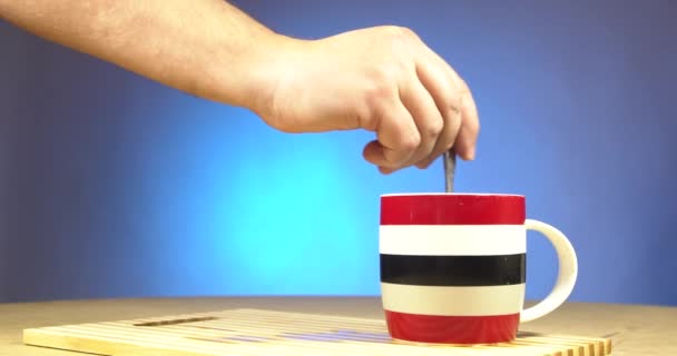 Main masculine mélanger le sucre dans une tasse transparente avec du thé
 - Séquence, vidéo