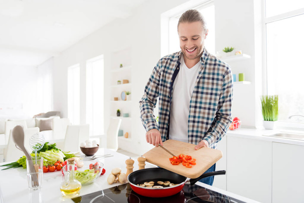 Portrait of his he nice attractive cheerful focused guy making fresh delicious domestic cookery classes hobby courses spending weekend free time in modern light white interior style kitchen - Fotó, kép