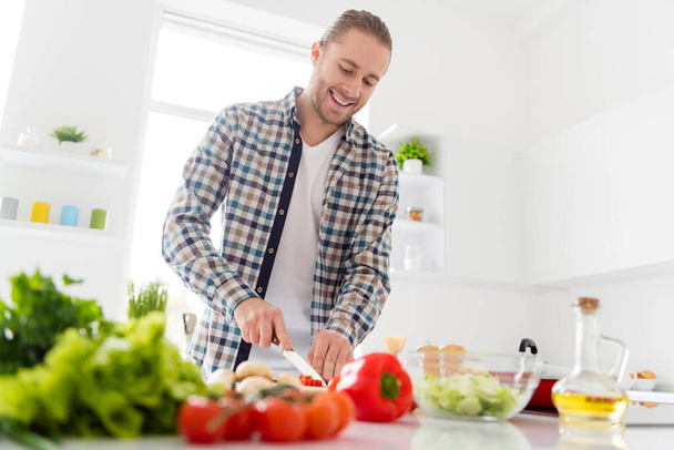 Portrait of nice attractive cute cheerful cheery focused guy making fresh delicious domestic dish dinner lunch enjoying good morning life lifestyle in modern light white interior style kitchen house - Φωτογραφία, εικόνα