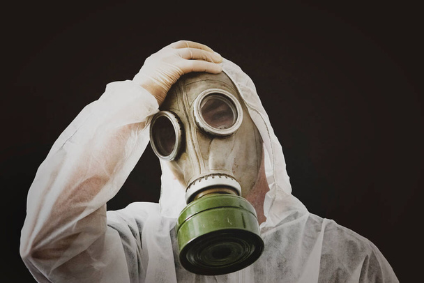virusinfectie concept. Man in beschermend pak en antigas masker op vuile zwarte achtergrond. Ebola, giftige gassen, biologische oorlogvoering, coronavirus, infecties en ziekten. Slechte ecologie. Slaap lekker - Foto, afbeelding