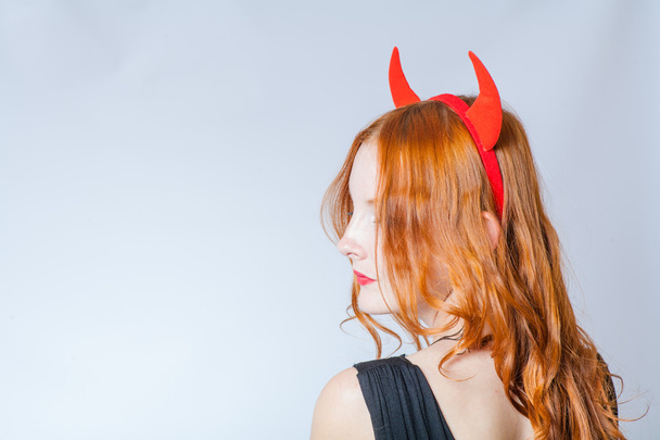 close up of a red haired girl with horns like a devil - Fotó, kép