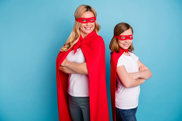 Photo of cool confident mommy lady little daughter spend time together carnival super woman girl costumes arms crossed heroes wear s-shirts red coat masks isolated blue color background - Foto, afbeelding