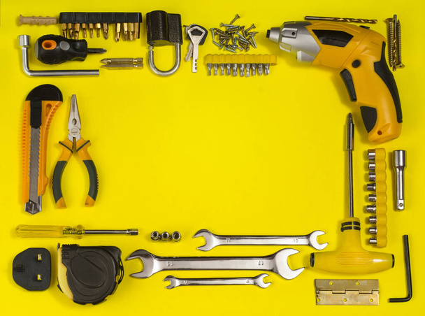 żółty zestaw narzędzi i przyrządów do ręcznej pracy i mocowania na żółtym tle. Koncepcja dnia ojców - Zdjęcie, obraz