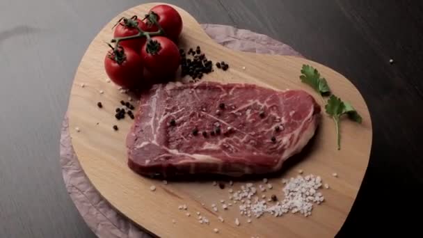 Rauwe biefstuk met specerijen op een donkere achtergrond. Bovenaanzicht met kopieerruimte. - Video