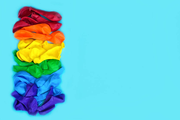 Bandera LGBT pintada aislada sobre un fondo azul. Globos multicolores de color símbolo LGBT. Copiar espacio, banner
 - Foto, imagen