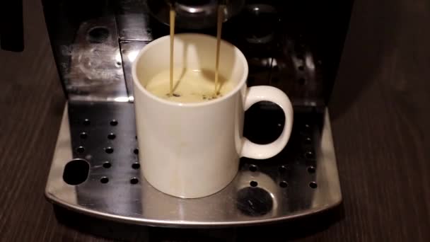 Świeżo pachnąca kawa jest wlewana do filiżanki. Automat do kawy. - Materiał filmowy, wideo