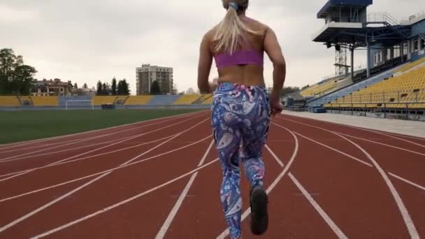 Athletic beautiful fitness cross, run in the stadium. Beautiful body. Blonde - Video, Çekim