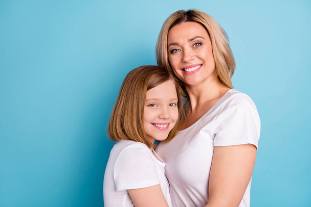 Profile photo of two people beautiful mommy lady small little daughter blonds hugging good mood best friends wear casual white s-shirts isolated blue color background - Fotografie, Obrázek