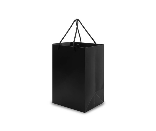 Zwarte papieren tas met handgrepen in zijaanzicht geïsoleerd op witte achtergrond met knippad. - Foto, afbeelding