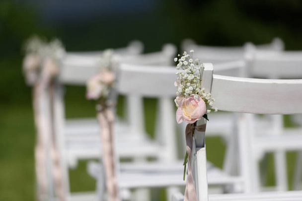 Chaise décorée avec des pivoines fleurs lors d'une cérémonie de mariage
 - Photo, image
