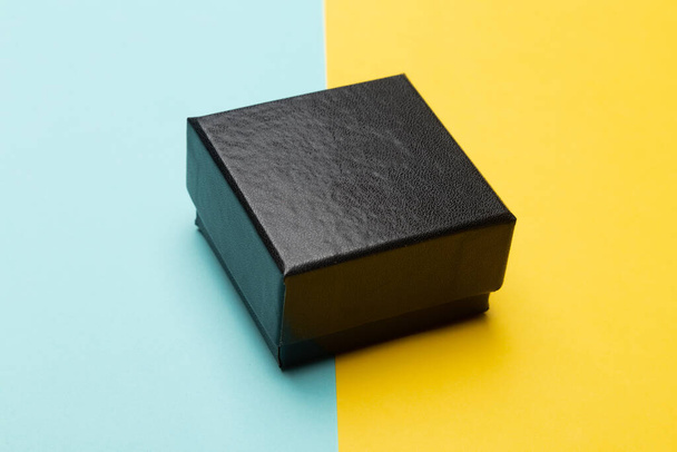 Упаковка из черного ящика на желтом полусинем фоне. - Фото, изображение