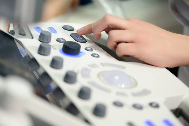 Female doctor performs diagnostics on a modern ultrasound machine. Close-up shot. - Φωτογραφία, εικόνα