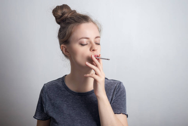 Joven chica caucásica fumando un cigarrillo, adicto a la nicotina
 - Foto, imagen