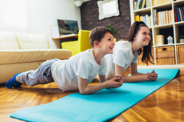 Children exercising at home. Family working out at home. - 写真・画像
