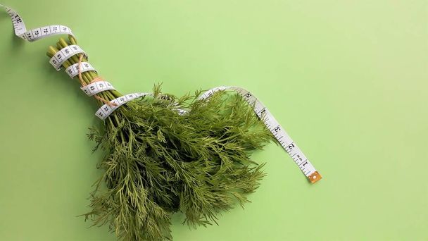 Čerstvá zelená zelenina zabalená v měřicí páskě.Koncepce cíle zhubnout, cíl stravy - Fotografie, Obrázek