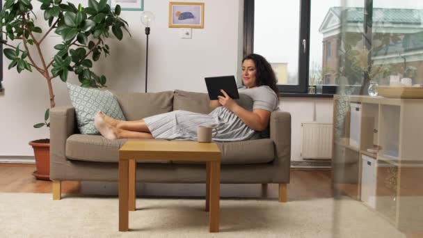 woman with tablet pc computer on sofa at home - Video
