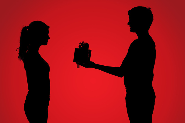 Silhouettes of couple with gift - Photo, Image