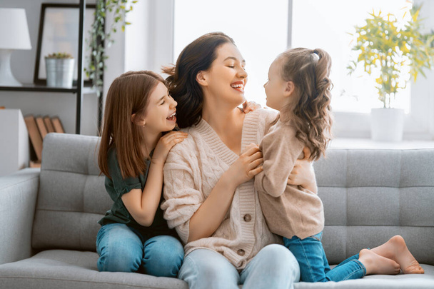 Happy mother's day! Mom and her daughters children girls are playing, smiling and hugging. Family holiday and togetherness.   - 写真・画像