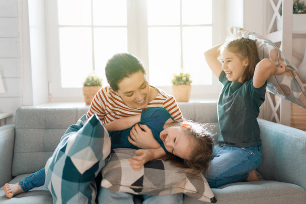 Happy loving family! The mother and her children girls are fighting pillows.  - Valokuva, kuva