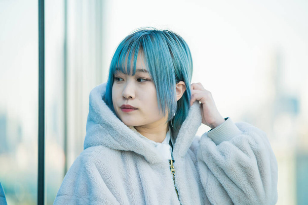 Νεαρή Ασιάτισσα με μπλε μαλλιά στη Σιμπούγια (Τόκιο, Ιαπωνία)) - Φωτογραφία, εικόνα