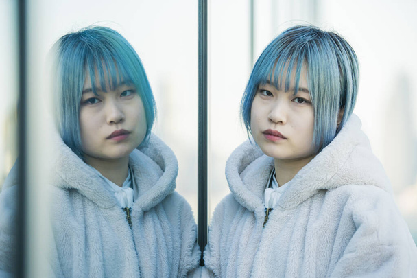 Fiatal ázsiai (japán) nő kék hajjal és tükörképével - Fotó, kép