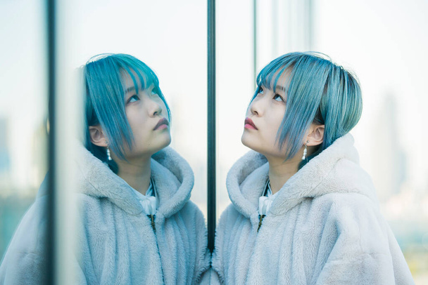 Giovane asiatica (giapponese) donna con i capelli blu e il suo riflesso
 - Foto, immagini
