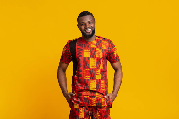 African guy in authentic clothes posing over yellow background - Фото, зображення