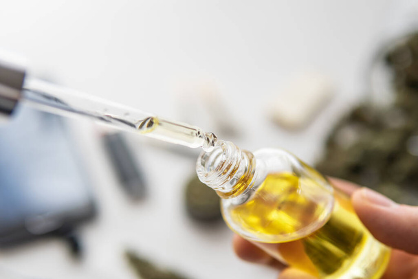 bottle of oil Cannabis in pipette in hand, medical marijuana concept, close up, hemp product, CBD cannabis OIL on white background, - Photo, Image