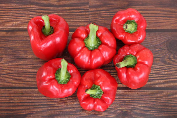 5 velké čerstvě umyté červené papriky na dřevěném stole - Fotografie, Obrázek