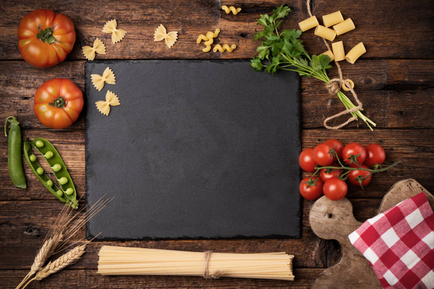 Lebensmittelzutaten für Pasta mit roten Tomaten, Petersilienblättern auf Holzgrund, Draufsicht mit Kopierraum - Foto, Bild