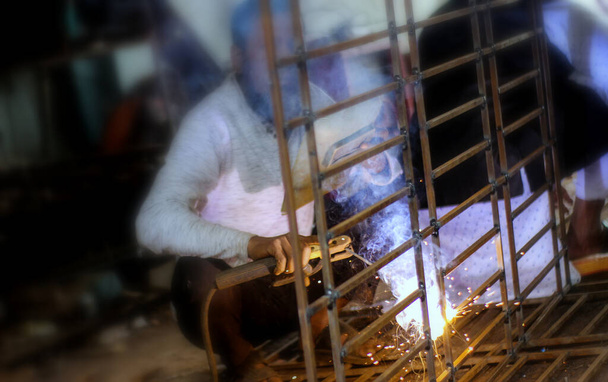 Дакка, Бангладеш 20 квітня 2020 року: зварювання металу. Іскри від електричного опалення. Залізо, матеріали. Художні зварювальні іскри легкі, промисловий фон
 . - Фото, зображення