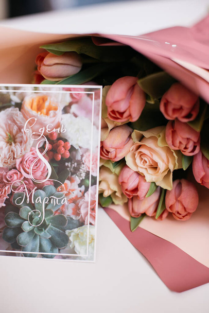 Strauß von rosa und pfirsichfarbenen Blumen mit einer Grußkarte - Foto, Bild