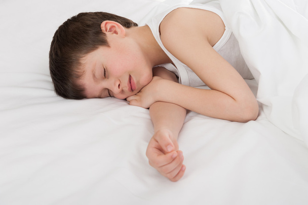 iloinen poika nukkuu valkoisessa sängyssä
 - Valokuva, kuva
