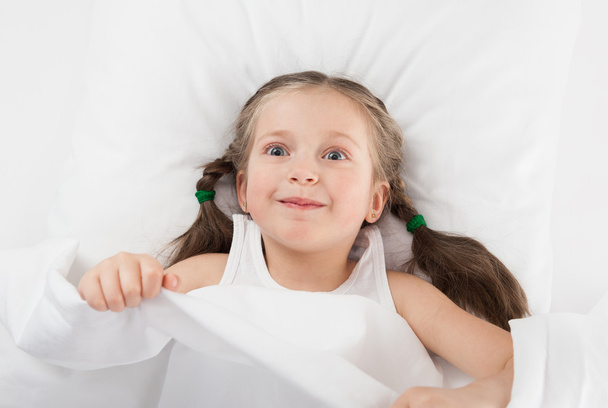 cheerful girl in white bed - Фото, изображение