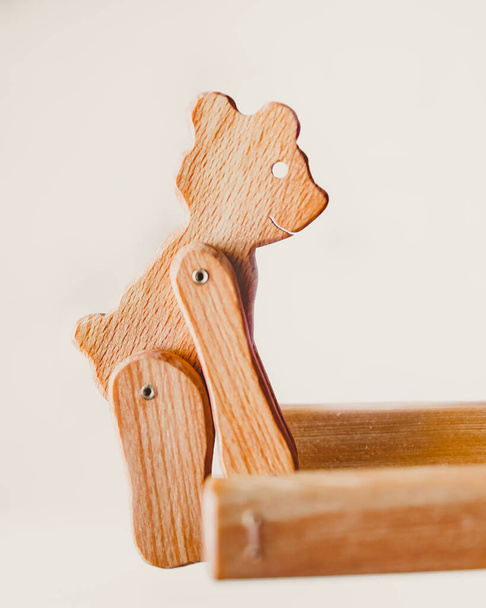 Drewniany miś podnosi deski przednimi łapami. Ekologiczna interaktywna drewniana zabawka, element wnętrza, puzzle. - Zdjęcie, obraz