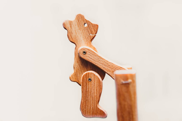 Drewniany Niedźwiedź huśta się na pionowym pręcie. Stylowa interaktywna drewniana zabawka, element wnętrza, puzzle, które rozwija mózg. Tradycyjny motyw. - Zdjęcie, obraz