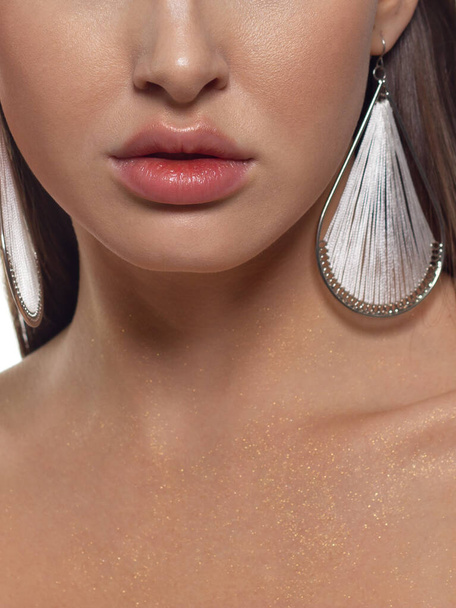 Cosmetics, makeup and trends. Bright lip gloss and lipstick on lips. Closeup of beautiful female mouth with natural lip makeup. Beautiful part of female face. Perfect clean skin in red light - Фото, зображення