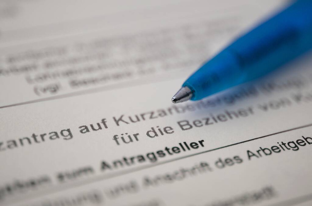 ドイツ語の出願フォーム鉛筆で短時間手当、翻訳:企業の従業員のための短時間手当の申請 - 写真・画像