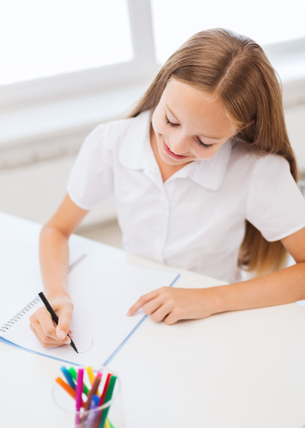 Little student girl drawing at school - Foto, Imagen