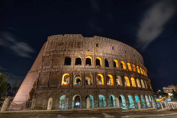 Italian monument to the Colosseum in the center of Rome in the illuminated night - Photo, Image