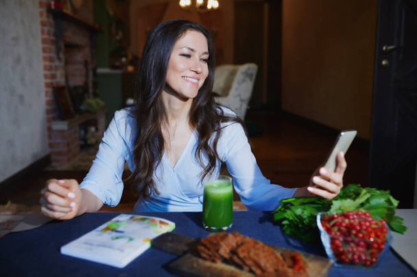 Mujer en la mesa con comida saludable haciendo foto autofoto móvil para su blog de Internet
 - Foto, Imagen