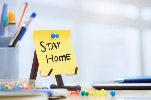 Stay Home tekst op zelfklevende notitie op kantoor - Foto, afbeelding