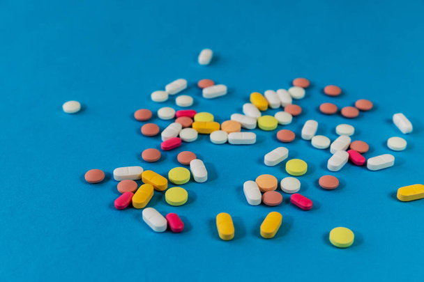 Different medicine pills, tablets on blue background. Many pills and tablets with space for text. Health care. Top view. Copy space. New image. Pharmaceutical picture. Closeup. Close-up. Soft focus - Foto, imagen