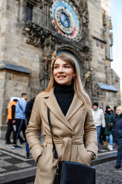 Attraktive Blondine im beigen Mantel spaziert durch die Altstadt - Foto, Bild
