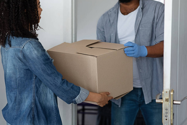 Невпізнаваний чорний чоловік доставки пакет для жінки домовласник
 - Фото, зображення