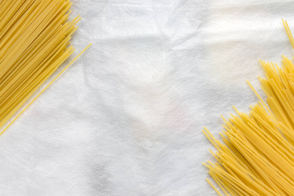 Паста Спагетті лежить на білому тлі. Коронавірусні продукти харчування та постачання для бідних людей під час самоізоляції
 - Фото, зображення