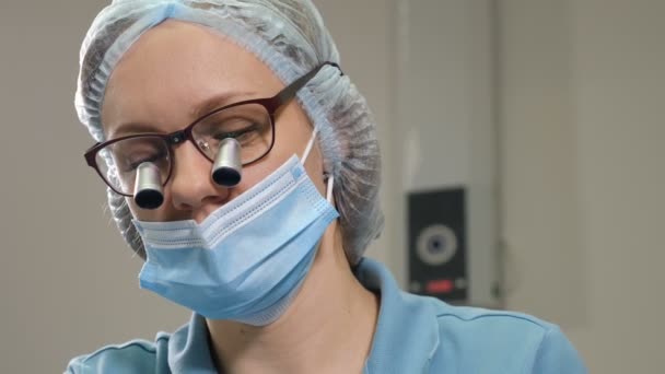 Close-up view of spectacles magnifying binocular on young female dentist during dental treatment. orthodontist in binocular on eyes making dental surgery. 4 k footage - Séquence, vidéo