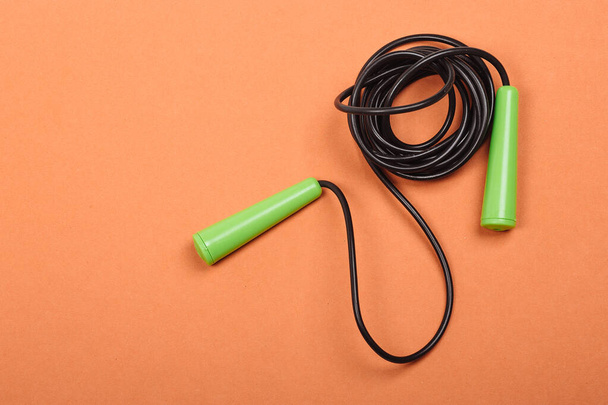 Skipping rope on bright orange background, top view close up. Concept is cardio, healthy lifestyle. - Fotoğraf, Görsel