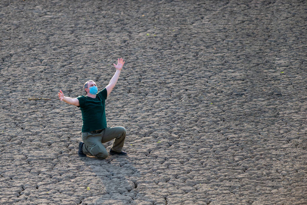 L'uomo alza le mani e prega per la pioggia in terra asciutta
 - Foto, immagini